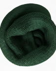 Green knitted scarf coiled up on a white background