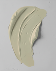 Green cream face mask on a light gray background
