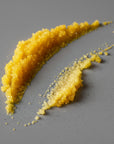 Turmeric lip scrub smeared on a gray background