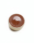 Small container of Chocolate lip balm on a white background